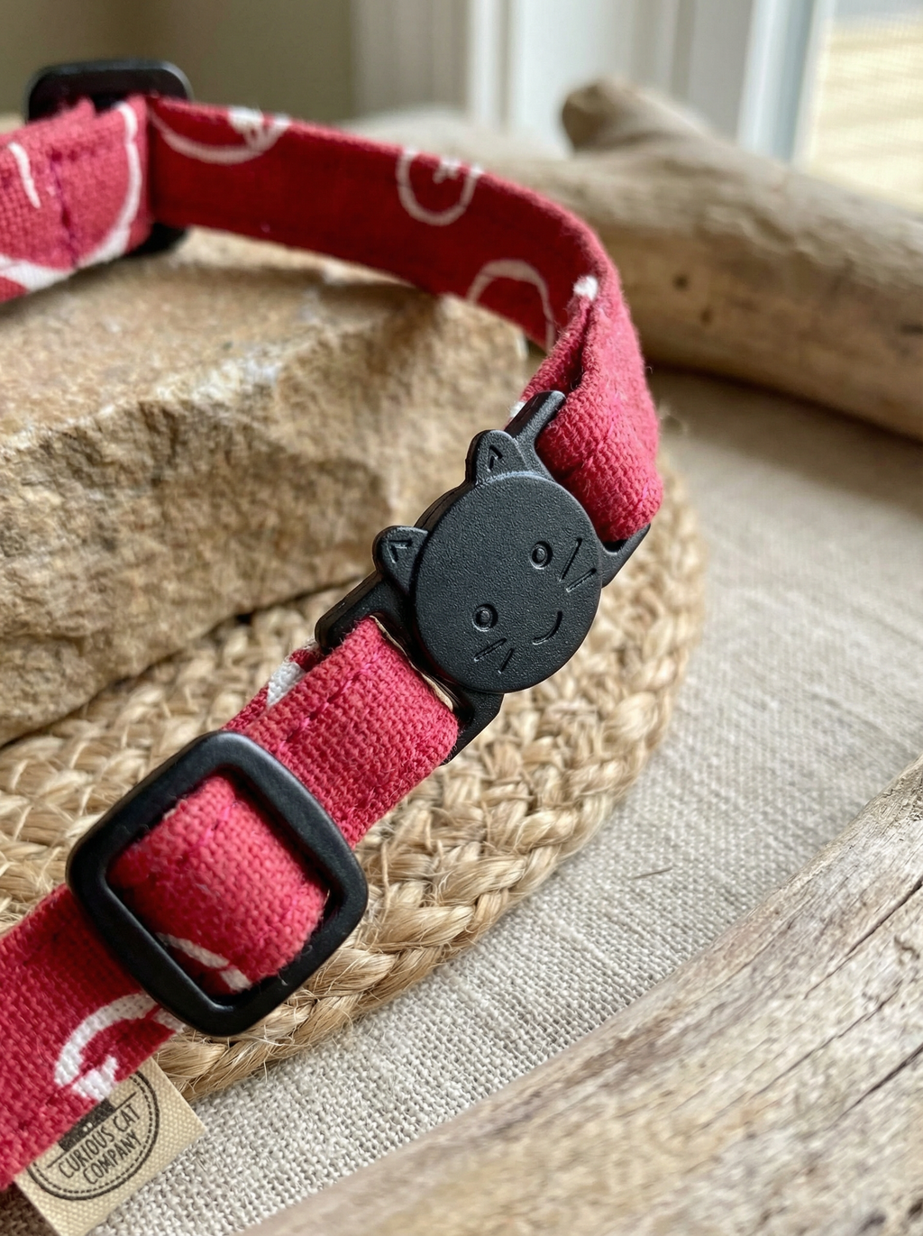 Red dog collar with black buckle on a woven mat