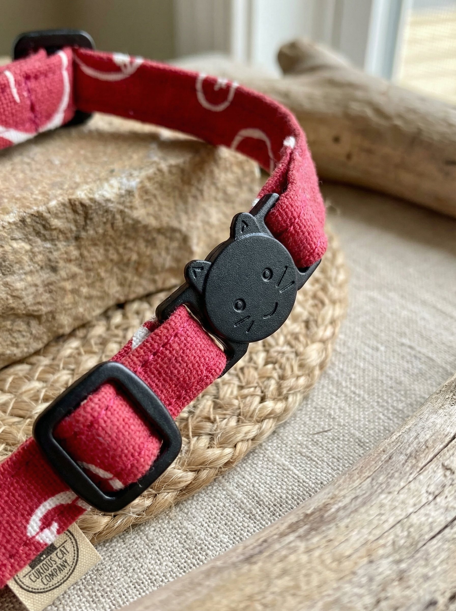 Red dog collar with black buckle on a woven mat
